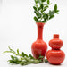 glossy red bud vases with greenery