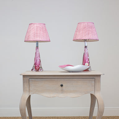 pair of pink val st lambert lamps on side table