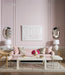 living room setting with pink walls and sofa with white grasscloth cocktail table