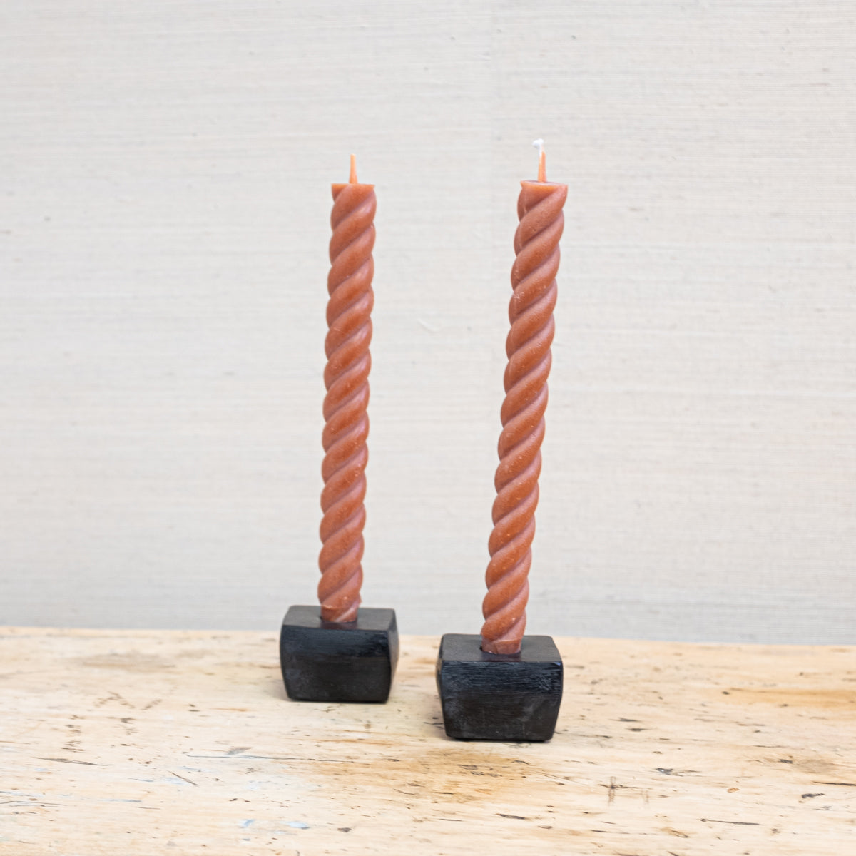 terra cotta color twist taper candles in black forged iron holders
